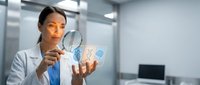 Female scientist examining digital molecular structure with magnifying glass in modern laboratory for research and analysis.