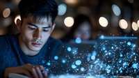 Young Asian male looking at glowing digital particles and bokeh lights emerging from electronic device in dark room, creating magical technology atmosphere.