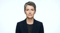 Professional mature businesswoman with short gray hair in dark suit jacket on white background isolated for corporate design and marketing materials.