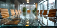 Empty modern corporate boardroom with glass table and leather chairs, ready for business meeting in contemporary office space.