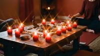 Mystical fortune telling session with tarot cards, crystals and glowing candles on wooden table creating atmospheric divination ritual scene.