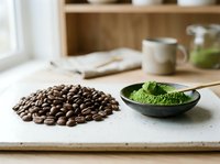 Coffee beans and matcha green tea powder on marble counter in modern kitchen setting for healthy lifestyle and beverage preparation concepts.