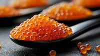 Fresh red caviar in black ceramic spoon on dark background, luxury seafood appetizer close-up with selective focus and natural light.