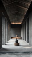 Minimalist corridor with concrete pillars and wooden ceiling leads to meditation space where person sits in contemplative pose on round wooden platform.