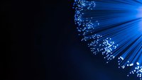 Blue fiber optic cables with glowing light streaks on dark background for technology and communication concepts.