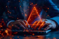 Glowing orange triangle hologram floating above laptop keyboard with bokeh light effects and blue tones, creating futuristic technological atmosphere.