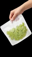 Hand holding a reusable zip bag filled with fresh green grapes, isolated on transparent background. Great for food storage, healthy eating, and kitchen clipart designs.