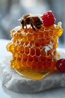 Honeycomb piece with honey bee and fresh raspberries on white marble, golden dripping honey cells in macro photography with soft natural lighting.