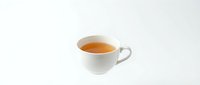 White ceramic cup filled with hot tea or coffee isolated on white background, ready for beverage, cafe, and restaurant design projects.