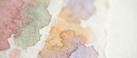 Soft watercolor paint blends in pastel pink, green, orange and purple hues creating organic flowing shapes on textured paper surface for artistic projects.