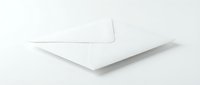 White envelope lying on a light surface, closed and ready for mailing, symbolizing communication, correspondence, and business messaging.