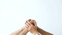 Three hands stacked together in unity gesture, isolated on white background, suitable for teamwork, collaboration, and partnership concepts for business and community projects.