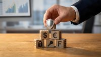 Businessman hand placing shield on wooden blocks with currency symbols and financial icons representing investment protection and risk management strategy.