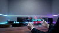 Hands holding transparent tablet displaying cyber risk alert hologram with glowing neon lines in modern office workspace for cybersecurity and digital threat concepts.