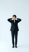 Stressed Asian businesswoman in dark suit covering ears with hands showing workplace pressure and mental health struggles on white background.