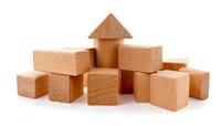 Natural wooden building blocks arranged in a small pile with a triangular roof piece, ideal for children's educational play and development.