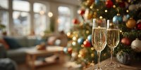 Two champagne flutes filled with sparkling wine on wooden table with decorated Christmas tree and cozy living room background for holiday celebration.