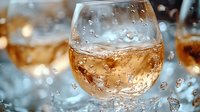Splashing rose wine in elegant glass with water drops and dynamic liquid motion against blurred background, golden hour lighting creates warm ambiance.