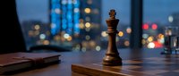Chess piece on wooden desk with city skyline bokeh lights at dusk, symbolizing strategy, business planning, and competitive advantage for corporate concepts.