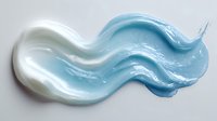 Smooth blue and white cream swirl texture with wavy pattern on white background, isolated for cosmetic product design or abstract art background.