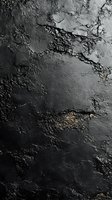 Dark textured stone surface with cracks and rough areas creating dramatic shadows and depth. Ideal for abstract backgrounds in design projects.