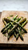 Grilled asparagus spears with fresh dill and sea salt on wooden cutting board. Healthy roasted green vegetables for spring cooking and Mediterranean cuisine.