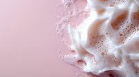 White soap foam bubbles on pink background, macro photography with soft focus and copy space for beauty and cosmetic products, spa and wellness concept.