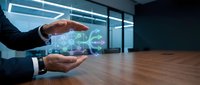 Businessman holding digital globe hologram above wooden desk in modern office space with windows, representing global business, technology, and international commerce.