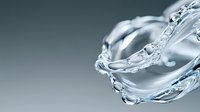 Clear water splash forming elegant spiral shape against gray background, frozen motion capturing liquid dynamics and transparency. Macro photography for cosmetic ads.