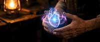 Elderly hands holding glowing magical energy orb with electric blue flames in mystical candlelit setting for fantasy and supernatural concepts.