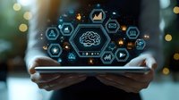 Digital brain with network of business analytics icons floating over tablet device in hands against dark background with bokeh lights.
