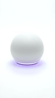 Spherical white smart device with glowing purple LED light ring on white background, isolated for product design and technology applications.