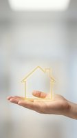 Hand holding glowing golden house outline symbol representing real estate investment, home ownership, property protection and housing market concepts.
