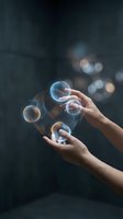 Hands reaching for floating soap bubbles against dark background with bokeh lights creating magical atmosphere for wellness and mindfulness concepts.
