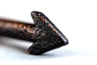 Extreme macro shot of black charcoal pencil tip on white background showing detailed texture and artistic drawing tool surface in selective focus.