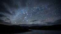 Night sky with constellation patterns connected by glowing lines over mountain landscape. Starry astronomy background for educational and scientific content.