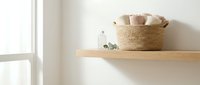 Minimalist bathroom shelf with woven basket and glass bottle in bright natural light creating clean modern spa-like atmosphere for home decor inspiration.