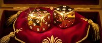 Pair of golden dice with red gemstones resting on crimson velvet cushion with gold tassels and ornamental details, luxury gaming and fortune concept.