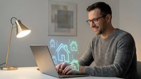 Middle-aged Caucasian man in glasses working on laptop with holographic house icons, representing real estate technology and smart home concepts.