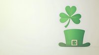 Green leprechaun hat with golden buckle and floating shamrock clover leaf on light beige background, minimal St Patrick's Day holiday design element.