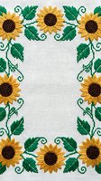 Embroidered sunflower border frame on white linen fabric with green leaves and vines, copy space center for text or design.