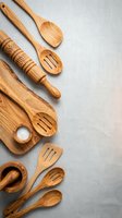 Wooden kitchen utensils and cutting board arranged on neutral background for cooking and food preparation flatlay with copy space.