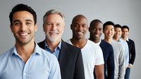Diverse group of smiling professional men standing in line, representing teamwork, leadership and workplace diversity in modern business environment.