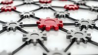 Connected metallic gear wheels network with one red cog standing out among silver ones, symbolizing leadership, innovation and unique business solution.