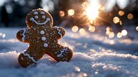 Cheerful gingerbread man cookie with icing decoration sitting in fresh snow at sunset with magical golden bokeh lights creating festive holiday atmosphere.