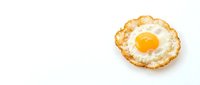 Crispy fried egg with golden yolk and lacy edges isolated on white background for breakfast menu design and culinary projects.