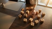 Professional businesswoman arranging wooden blocks with icons on office desk, strategic planning and organization concept for corporate development.