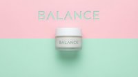 Skincare cream jar with balance text on pastel pink and mint green split background, minimalist cosmetic product display for wellness and beauty branding.