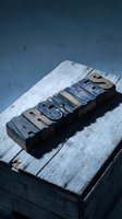 Vintage wooden letterpress blocks spelling ARCHIVES on weathered wood surface with dramatic lighting for typography and historical design projects.