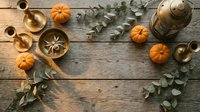 Autumn flat lay with orange pumpkins, brass candlesticks, eucalyptus leaves and lantern on rustic wooden background. Fall seasonal decoration frame.